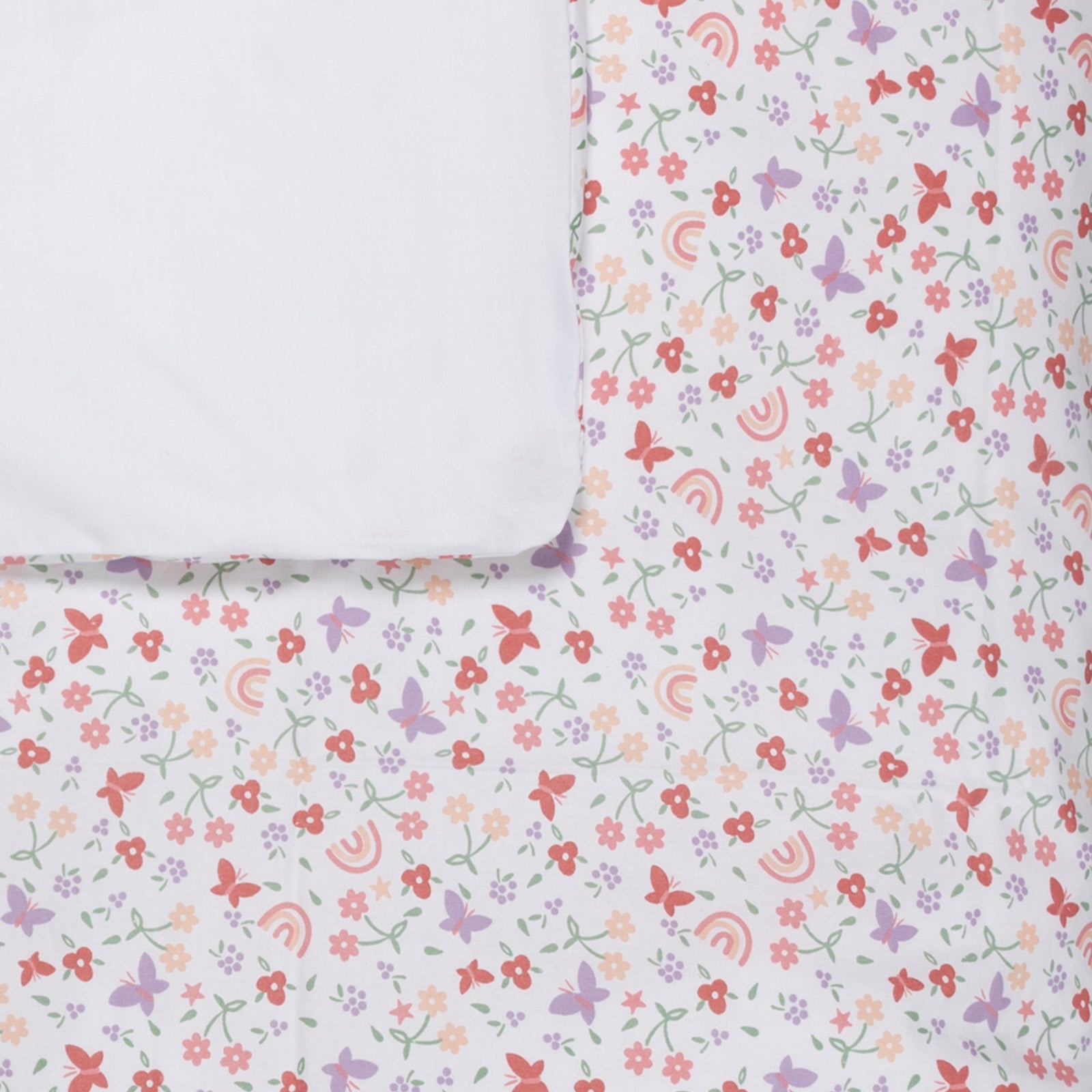 Detail van dekbedovertrek Linde met aan de voorzijde een vrolijke print met vlinders, bloemen en regenbogen. De achterzijde is uni wit katoen.