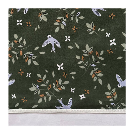 Laken Merel heeft een warme uitstraling door de mooie print met bloemen en vogels in lila, licht groen en camel op een donkergroene ondergrond.