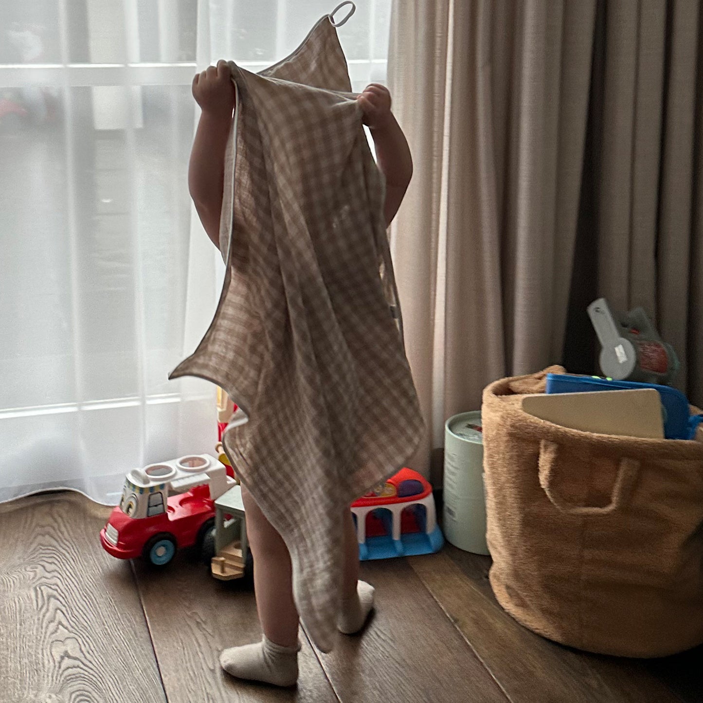 Peuter staand met BINK Bedding hydrofiele badcape beige Vichy ruit na het bad
