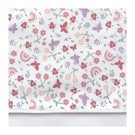 Laken Linde heeft een omslag van een leuke print met vlinders, regenbogen en bloemen en is mooi afgewerkt met een wit biasbandje. Vrolijke kleuren zoals roodroze, peach, lila en groen op een witte ondergrond.